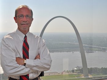 A photo of Tom Irwin in front of the arch
